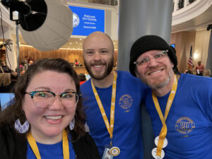 Photo of 3 CPPW members at the recent City Council meeting, wearing CPPW shirts and lanyards